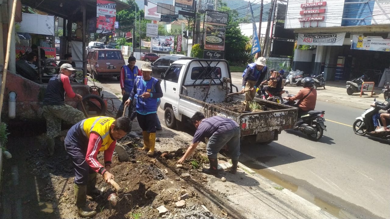 NORMALISASI : Petugas UPTD PUPR Wil. Tanjungsari mengeruk irigasi yang dipenuhi lumpur dan sampah kerap menimbulkan genangan air di Desa Hegarmanah Jatinangor. (For Radar Sumedang)
